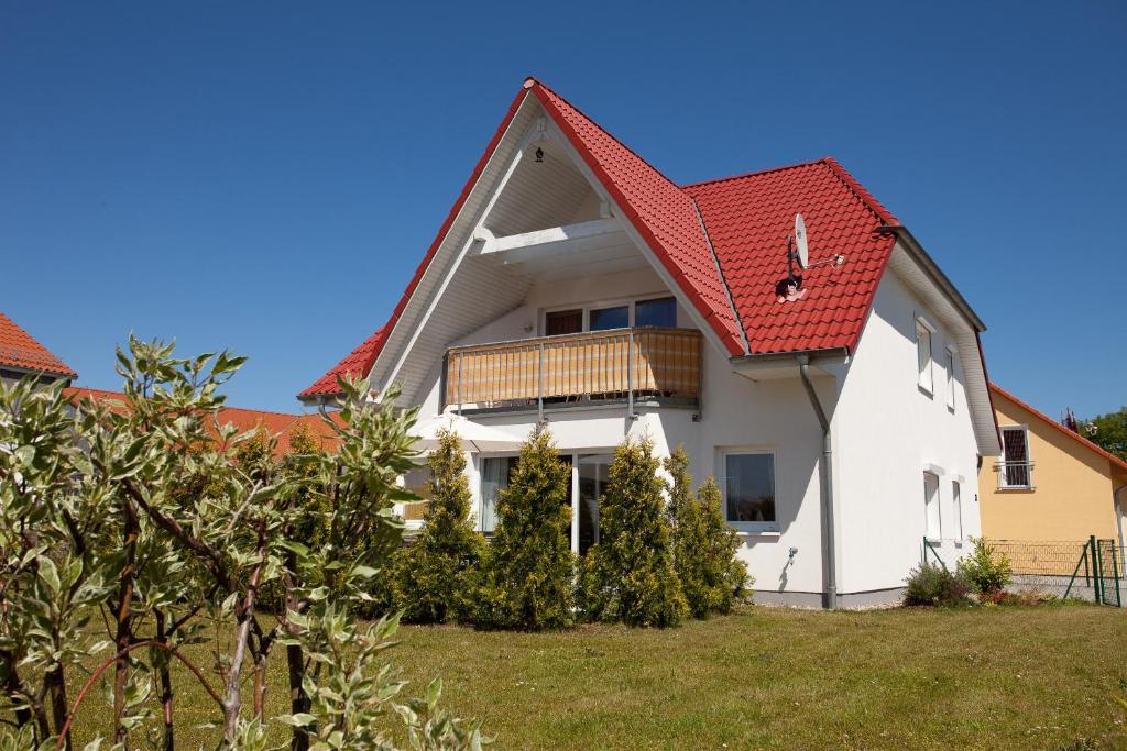 a white house with a red roof at Ferienhaus Stella in Glowe