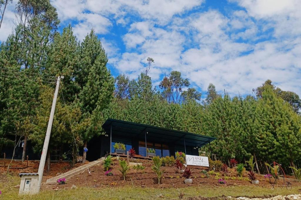 un edificio con un cartel en un jardín en Meraki_Paipa, en Paipa