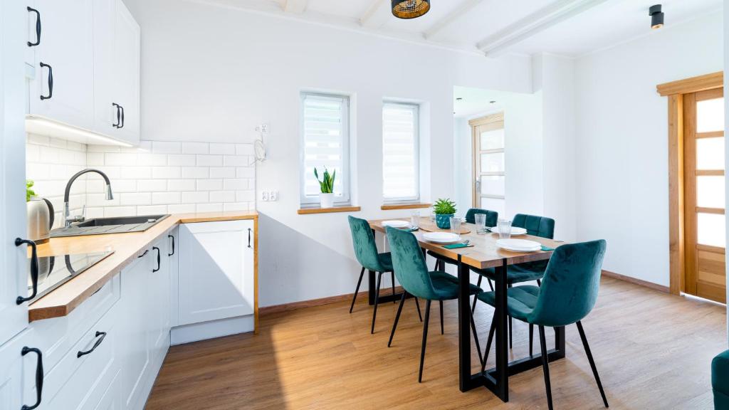 - une cuisine avec une table et des chaises en bois dans l'établissement Apartament Lux pod Karpaczem, à Miłków