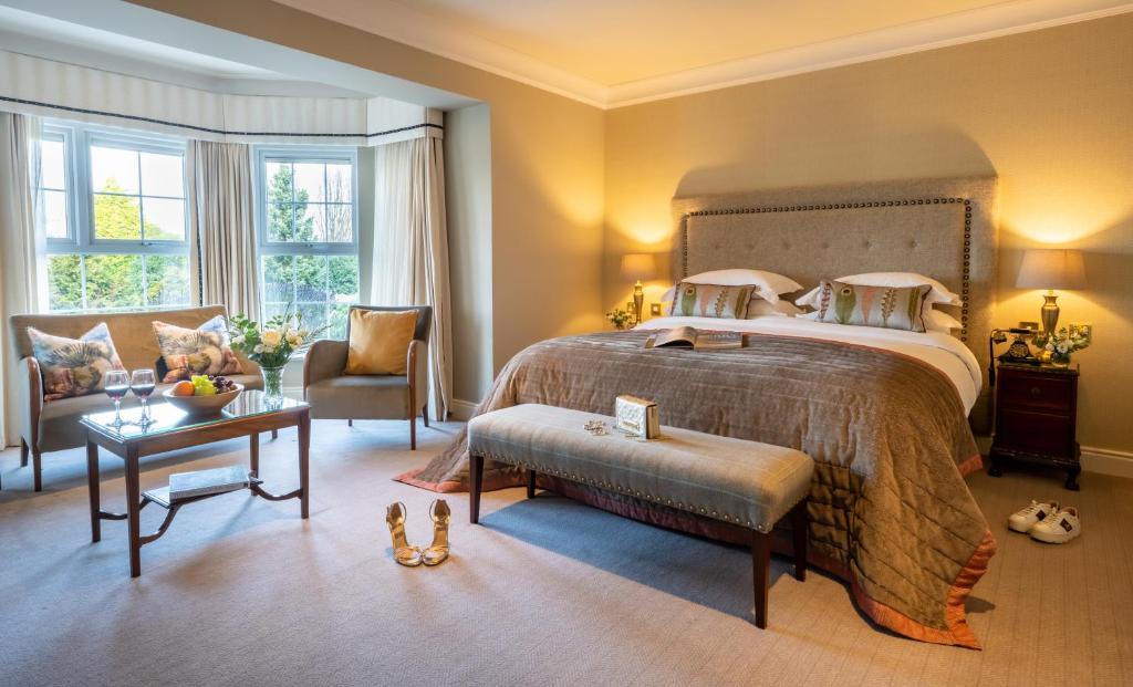 a bedroom with a bed and a chair and a table at Ballygarry Estate Hotel & Spa in Tralee