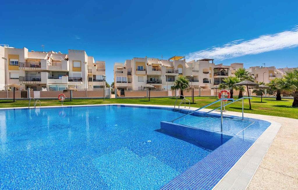 a large swimming pool in front of some apartment buildings at Apartamento El Toyo in Almería