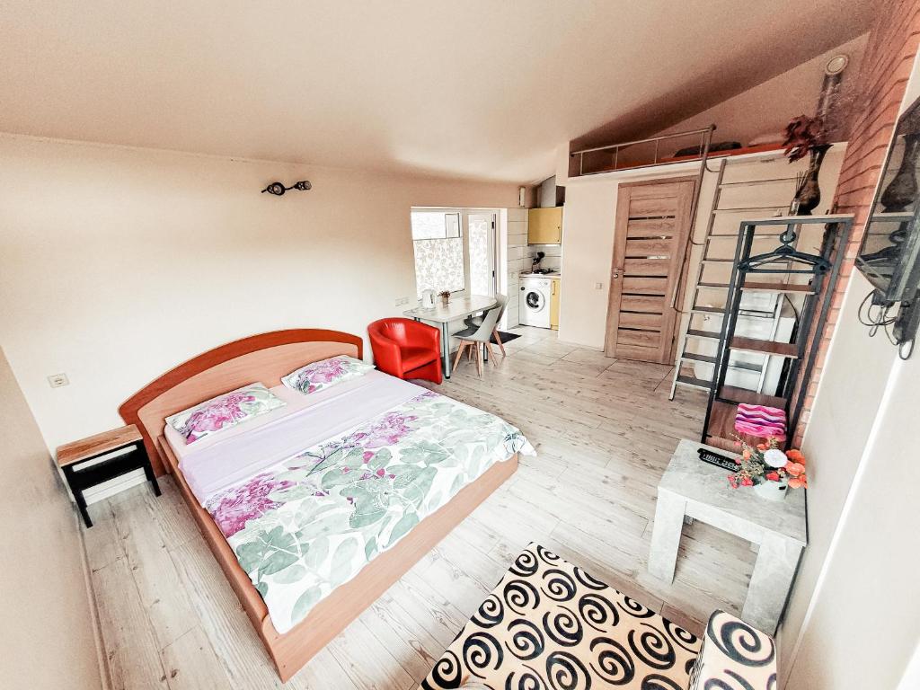 1 dormitorio con cama, mesa y escalera en Lampedziai Apartment en Kaunas