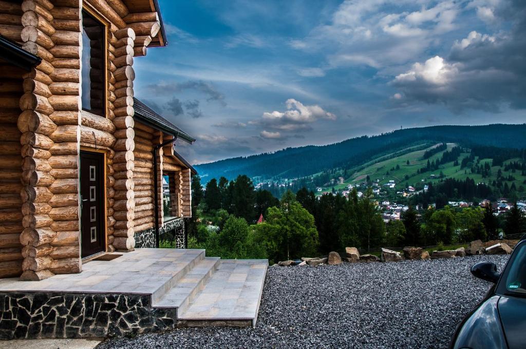 una veranda di una baita di tronchi con porta di Cabana Deac - Luxury Chalet a Vatra Dornei