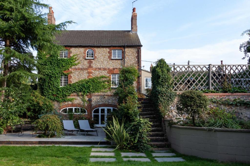 an old brick house with stairs in front of it at Relax, unwind and enjoy village life.... in Castle Acre