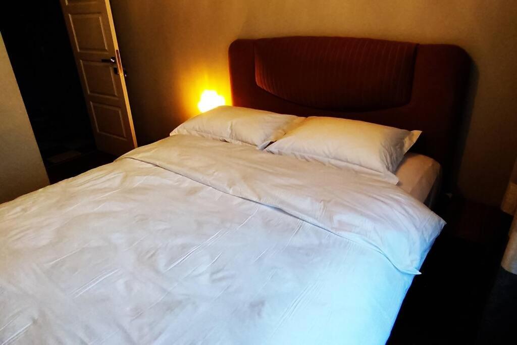 - un lit avec des draps et des oreillers blancs dans l'établissement Rental Room in a shared apartment near the airport, à Basaksehir