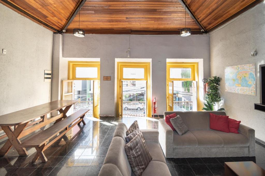 a living room with a couch and a wooden table at HMG - Praia de Botafogo in Rio de Janeiro