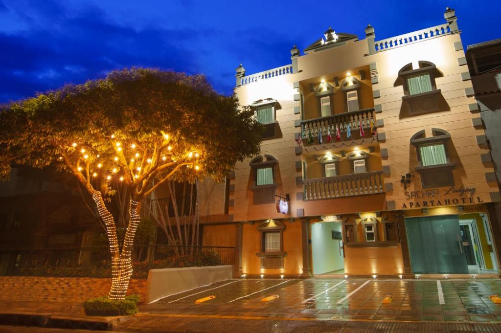 un edificio con un albero di fronte di Sachar Lodging Apartahotel a Bucaramanga