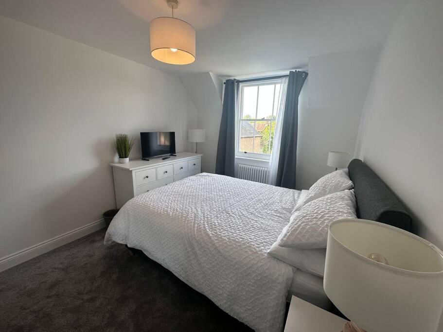 a white bedroom with a bed and a window at Riverside 3 Bed House in Winchester