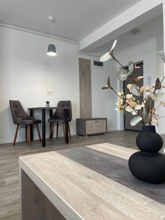 a black vase with flowers on a table in a room at Comfort & Luxury Apartaments PNMresidence in Timişoara