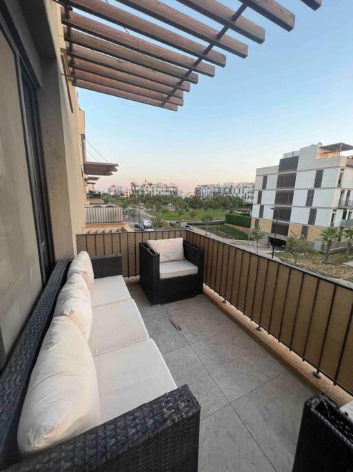 a balcony with a couch and a view of a city at دوبلكس بيفرلي هيلز اربع غرف الشيخ زايد فرش مودرن in Sheikh Zayed