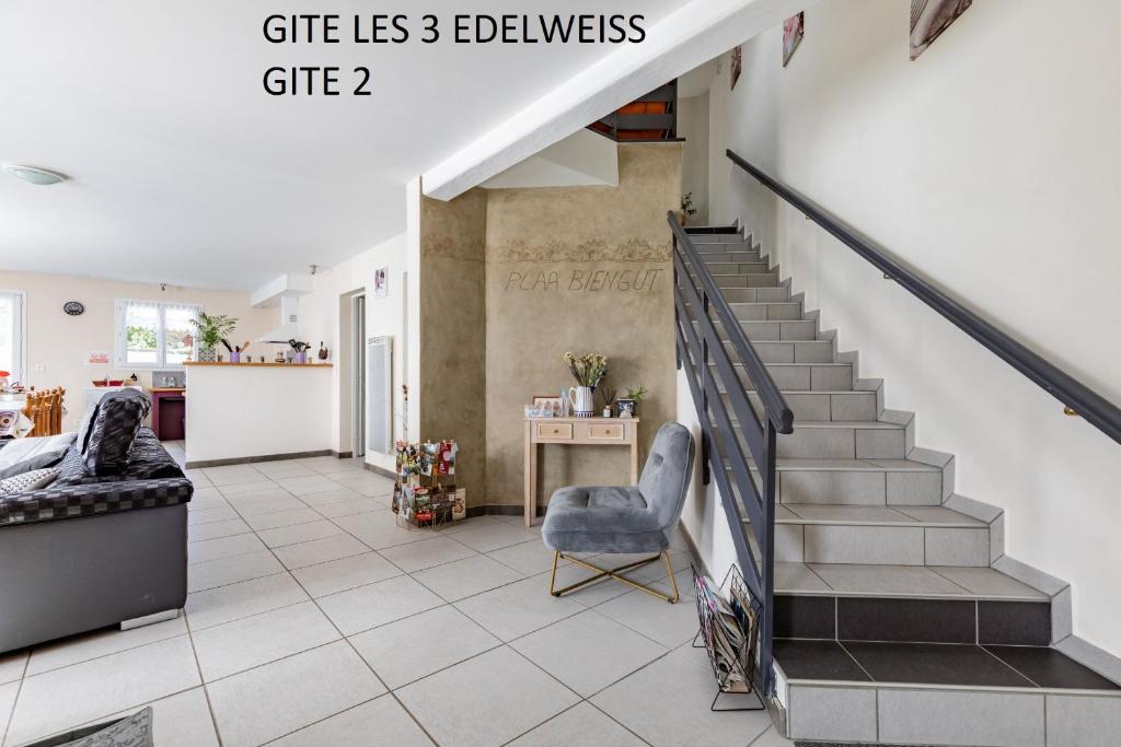 un salon avec un escalier, une chaise et une table dans l'établissement Les 3 Edelweiss - GITE 1 OU GITE 2, à Arette