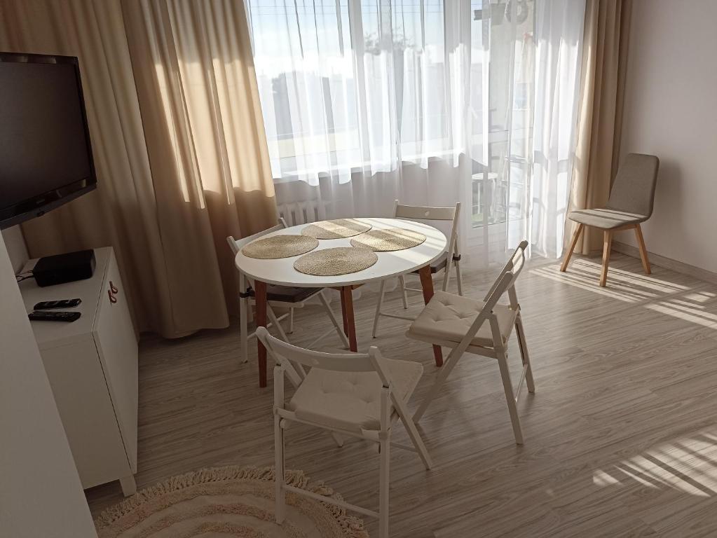 comedor con mesa, sillas y TV en Apartament przy Motławie en Gdansk