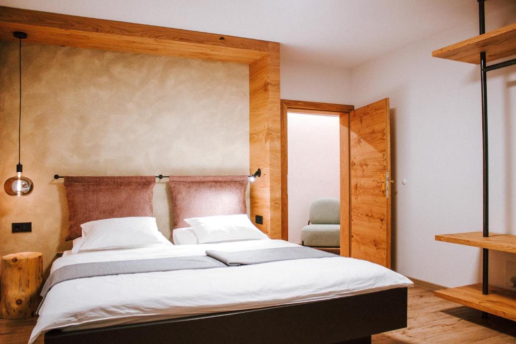 een slaapkamer met een groot bed met een houten hoofdeinde bij Hotel Schönberg B&B in Rio Bianco