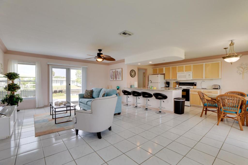 Una sala de estar con un sofá y sillas y una cocina. en Pet-Friendly Port Charlotte Home with Canal Access!, en Port Charlotte