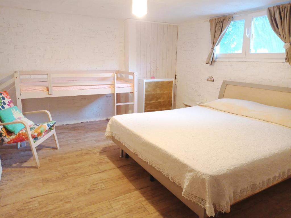 um quarto com uma cama, um beliche e uma cadeira em Valle Rubicone em Gatteo