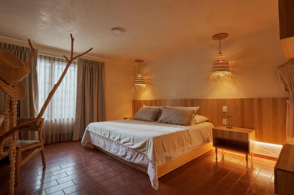 - une chambre avec un lit et deux lampes pendant dans l'établissement Hotel Materia, à Oaxaca