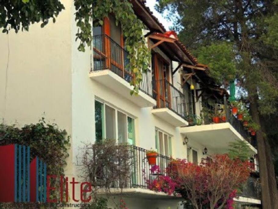 a white building with balconies and plants on it at Encantador loft! por el lago in Juriquilla