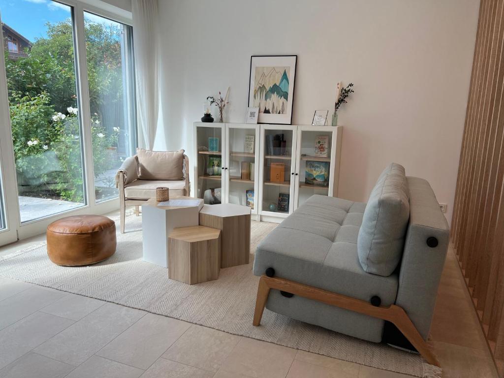 a living room with a couch and a chair at Design Apartment Alpenvorstadt in Holzkirchen