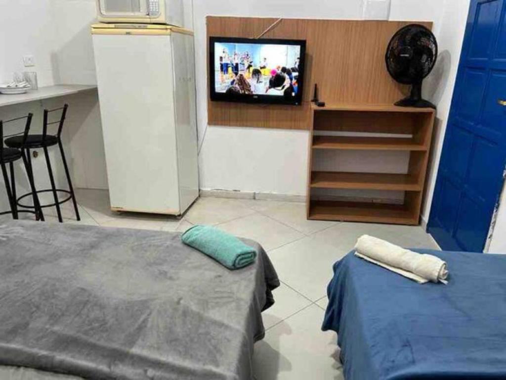 a room with a tv and a bed and a table at Studio Aconchegante Ao lado Expo Center Norte SP in São Paulo