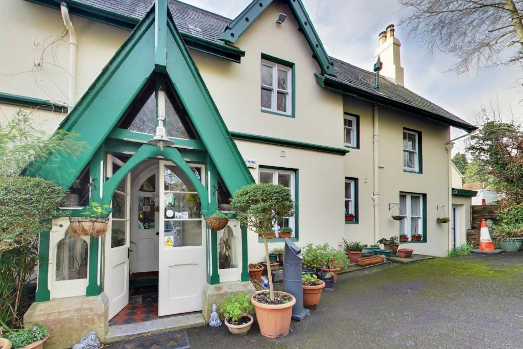 una casa con un edificio verde e bianco con piante in vaso di Robin Hill House Heritage Guest House a Cobh