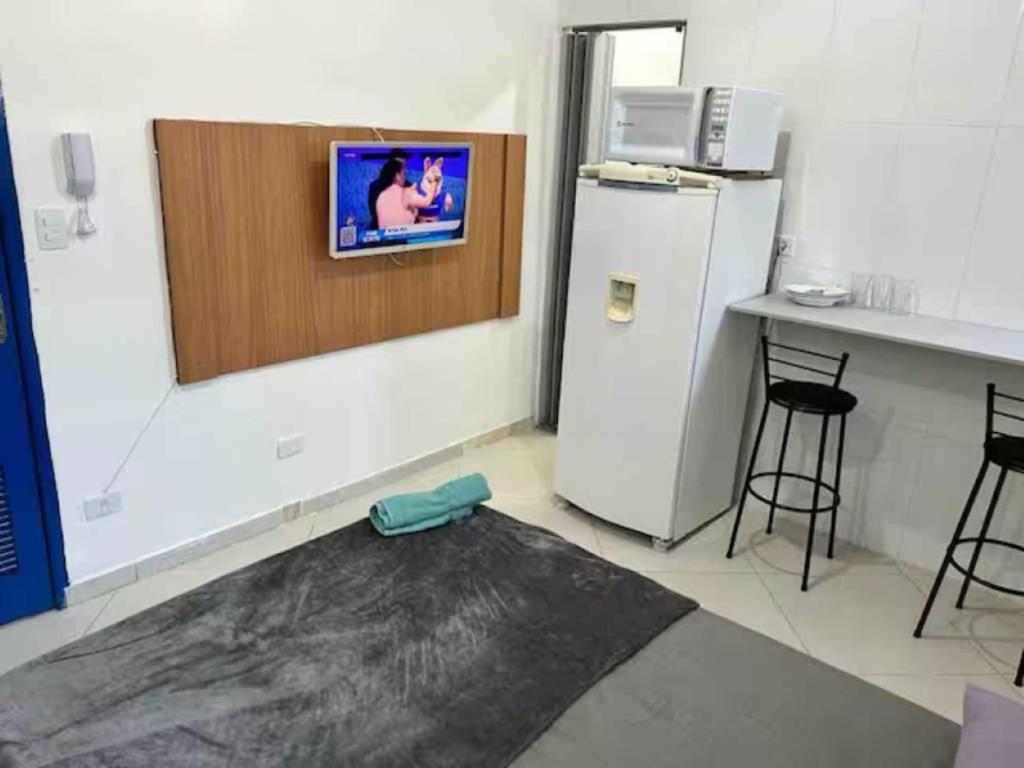 a kitchen with a refrigerator and a counter with a table at Estudio na Vila Guilherme Ao lado Expo Center Norte in São Paulo