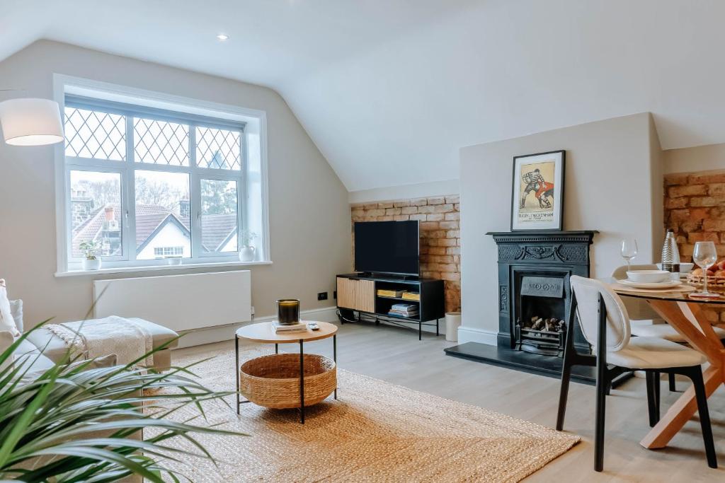 a living room with a table and a fireplace at Spring Grove Apartment - Central Harrogate in Harrogate