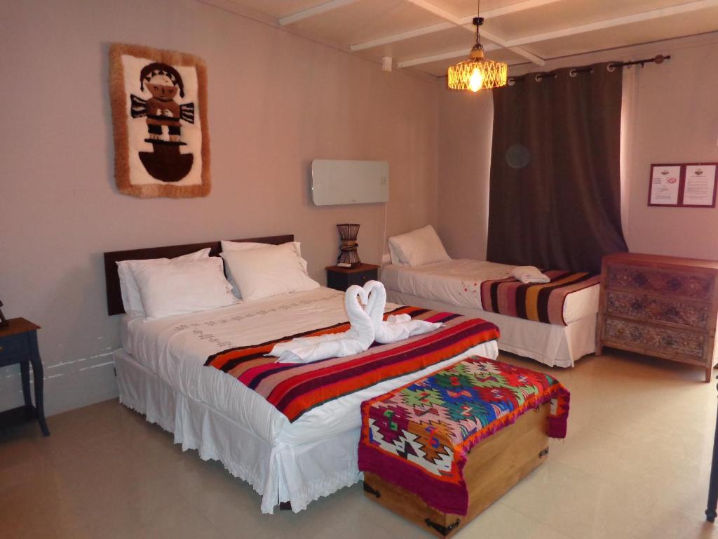 1 dormitorio con 2 camas y toallas. en Cabañas Antay, antes Casa Kirckir, en San Pedro de Atacama