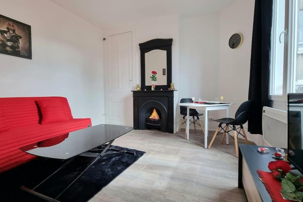 - un salon avec un canapé rouge et une cheminée dans l'établissement Chez K&D Studio Rouge Le Havre, au Havre