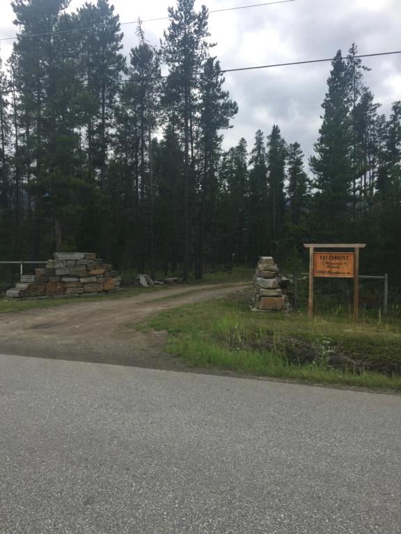 um sinal no lado de uma estrada com árvores em Valemount Mountain Retreat Guesthouse em Valemount