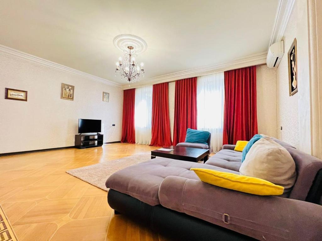 a living room with a couch and a television at Superb Central Location! Spacious and Comfortable 1 Bedroom + Jacuzzi, Next To Northern Avenue in Yerevan