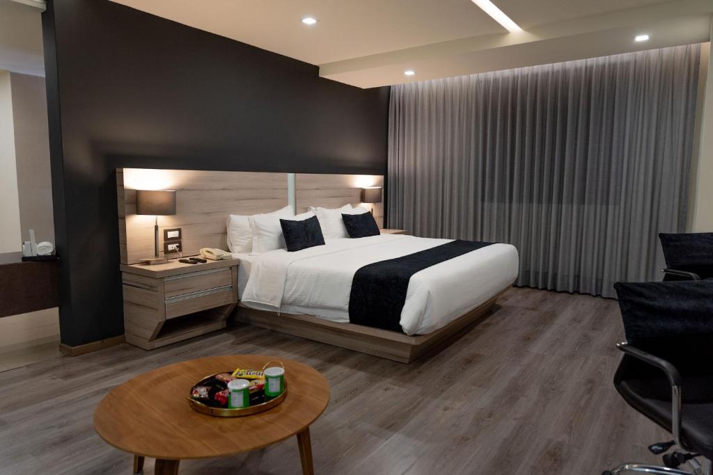 een hotelkamer met een bed en een tafel bij Domun Hotel in Querétaro