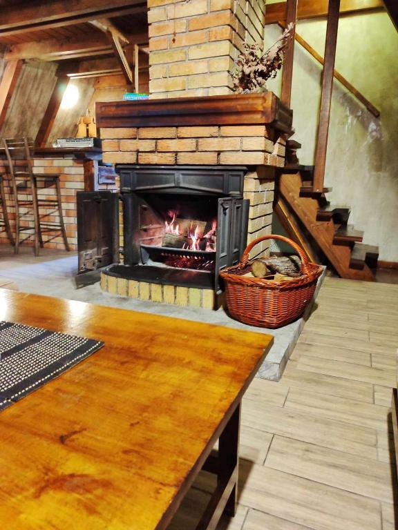 a fireplace in a room with a wooden table and a table sidx sidx at Vila Treska 98 in Kopaonik