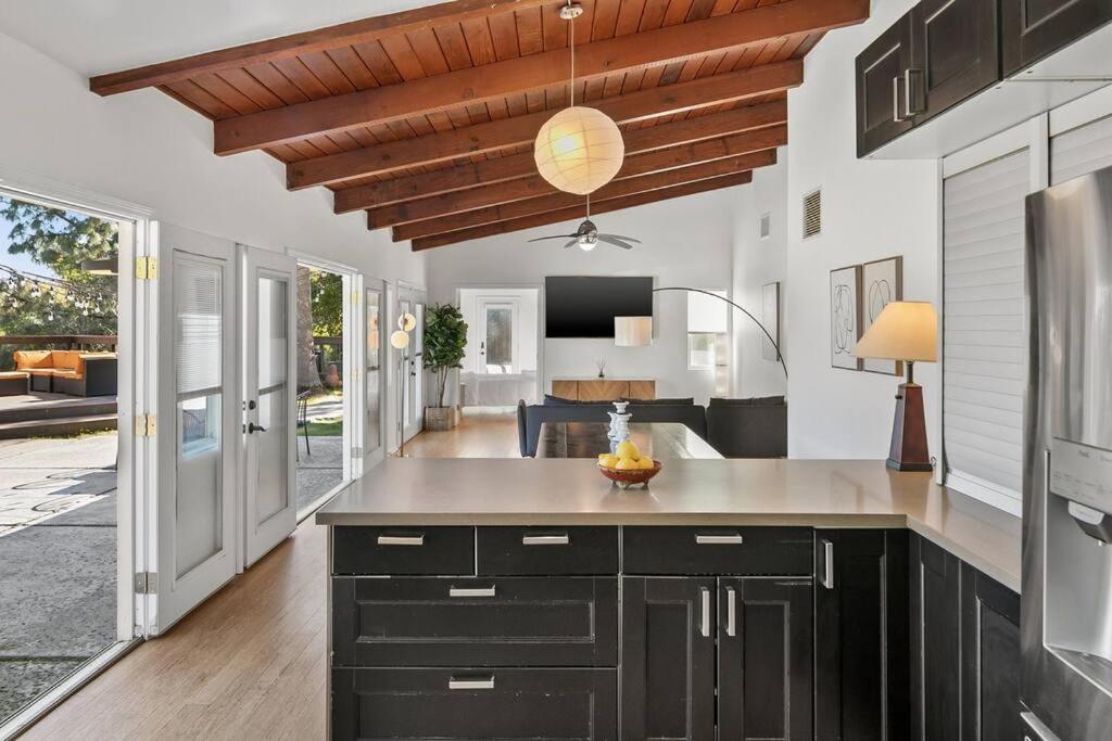 a kitchen with black cabinets and a wooden ceiling at Hillside Canyon, Private Home W/ Pool and Nature in Los Angeles