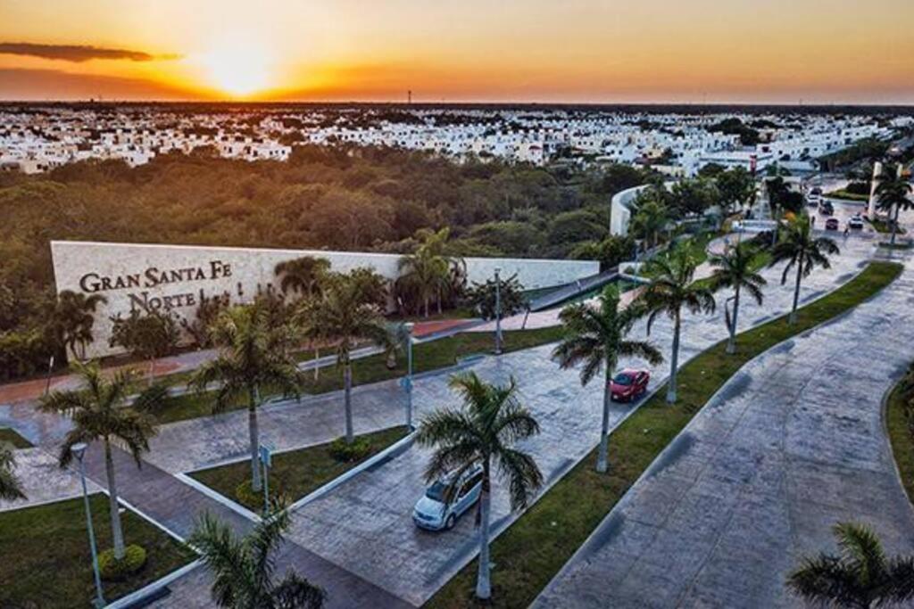 a sunset over a parking lot with palm trees at Casa de Descanso y Aventuras en zona privada in Mérida