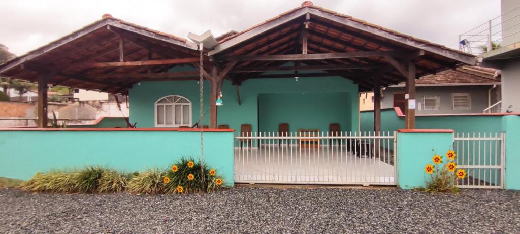 a blue house with a white fence and a gate at Casa Verde in Joinville