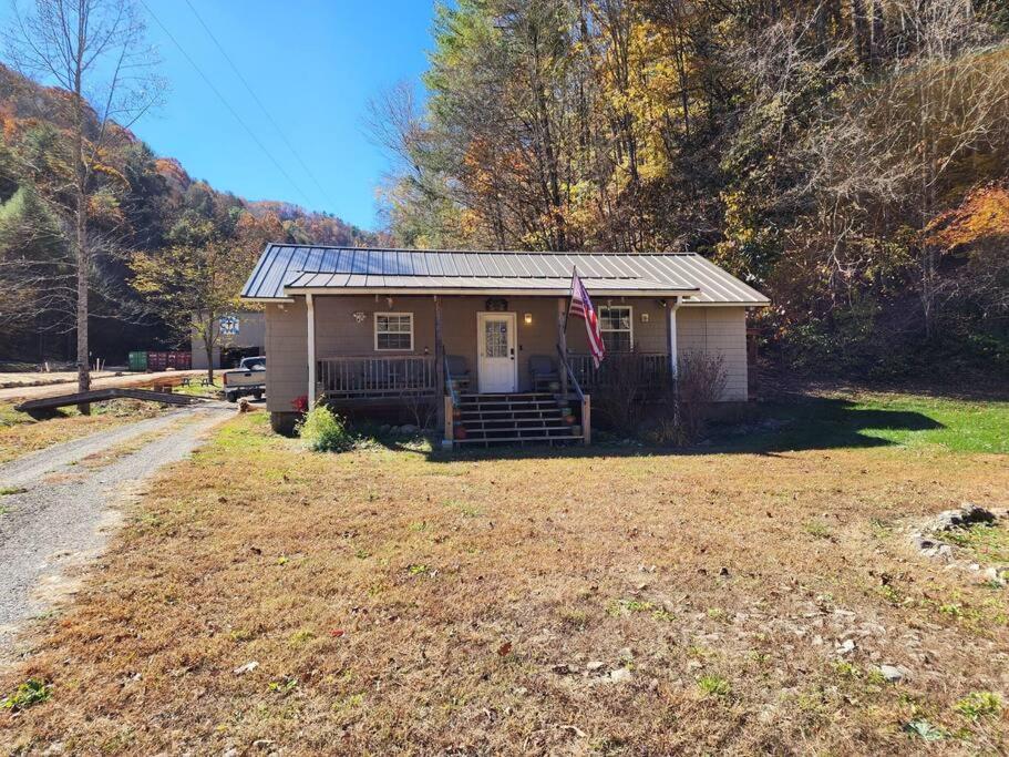 a small house with a flag in a yard at 2 bed, 1.5 bath cottage across from Watauga Lake in Butler
