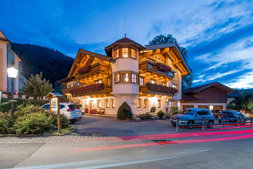 a large building with cars parked in a parking lot at Gästehaus Brantlhof Zimmer und Ferienwohnungen in Going am Wilden Kaiser in Going am Wilden Kaiser