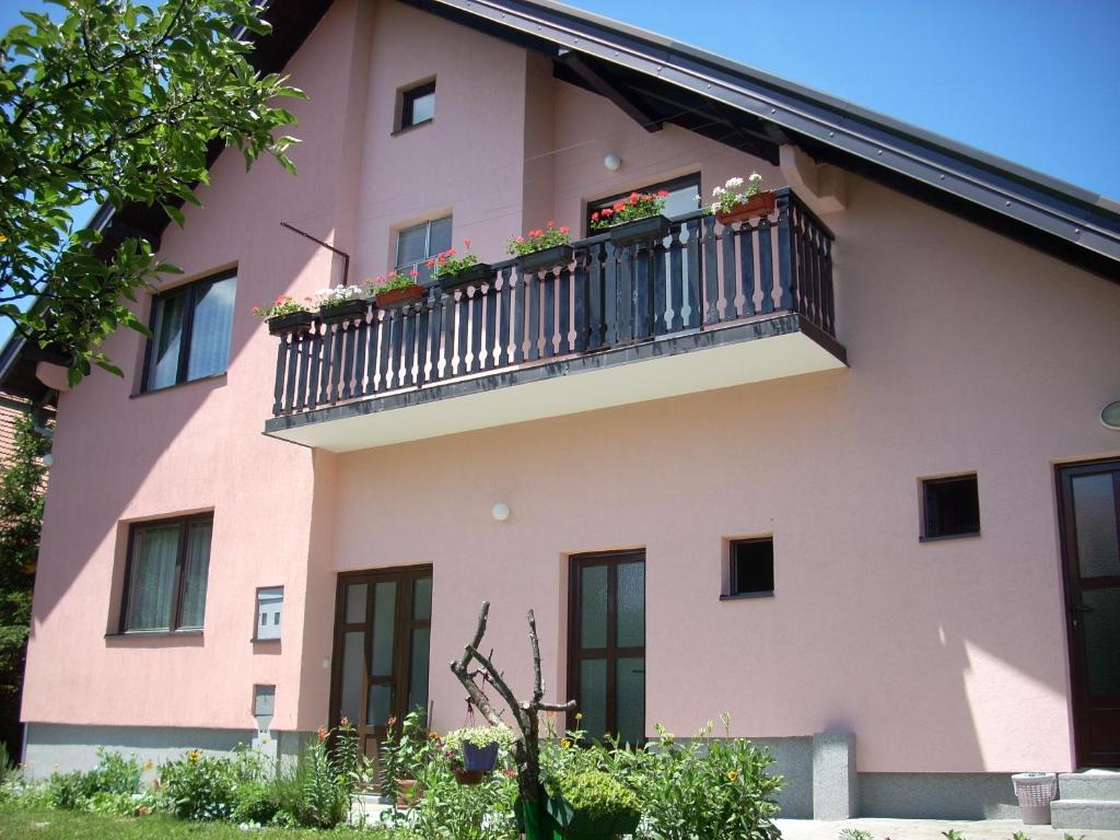 un edificio rosa con un balcón con flores. en Apartments Jeca, en Zlatibor