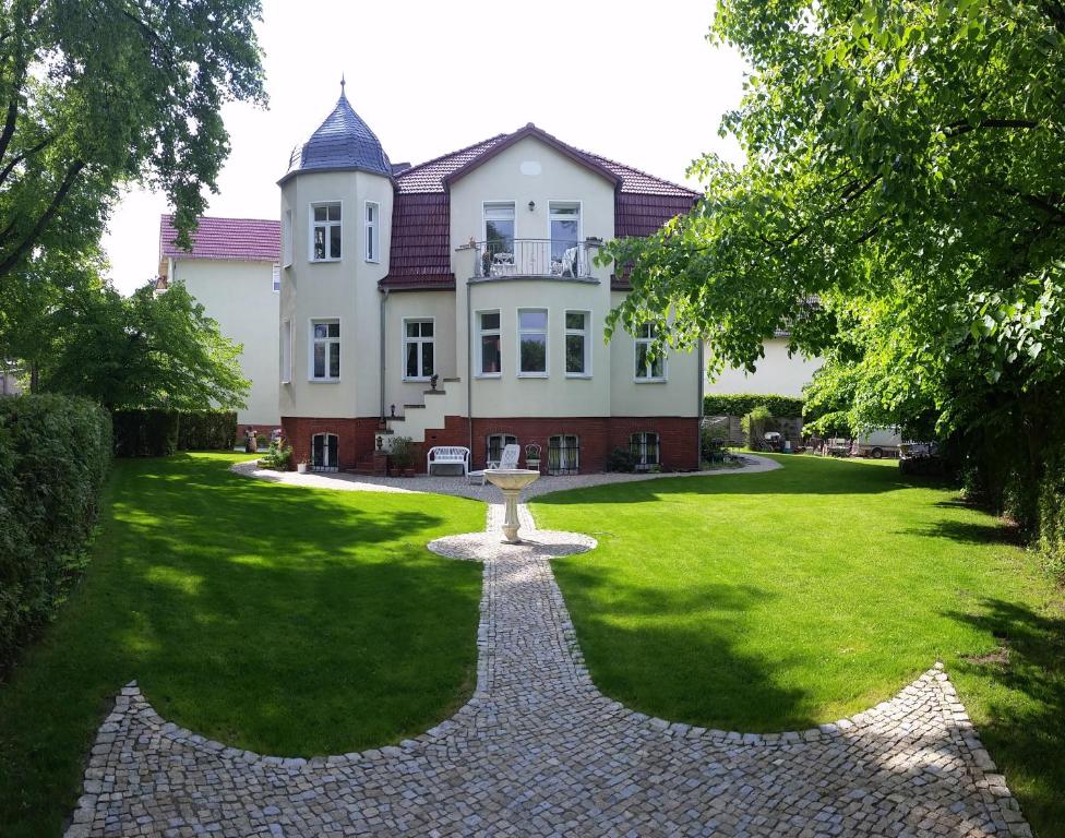 ein großes Haus mit einem Park davor in der Unterkunft Villa Weigert in Birkenwerder