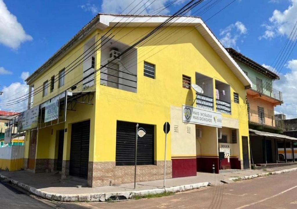 un edificio amarillo en la esquina de una calle en Residencial Margarida APART 5 en Presidente Figueiredo