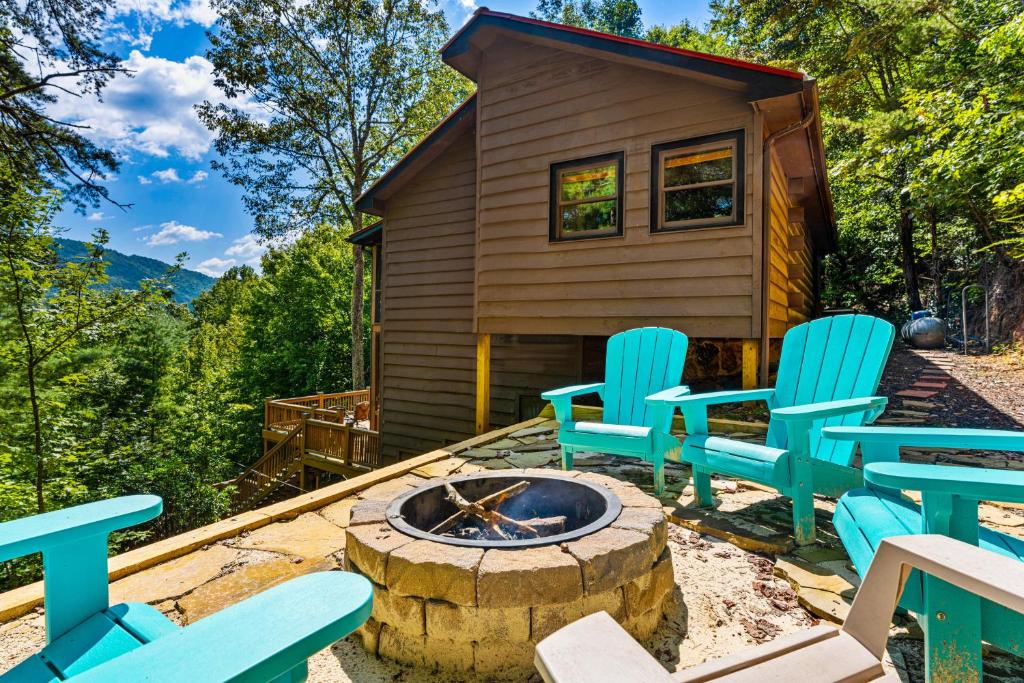 ein kleines Haus mit blauen Stühlen und einer Feuerstelle in der Unterkunft Antler Ridge Hideaway in Blue Ridge