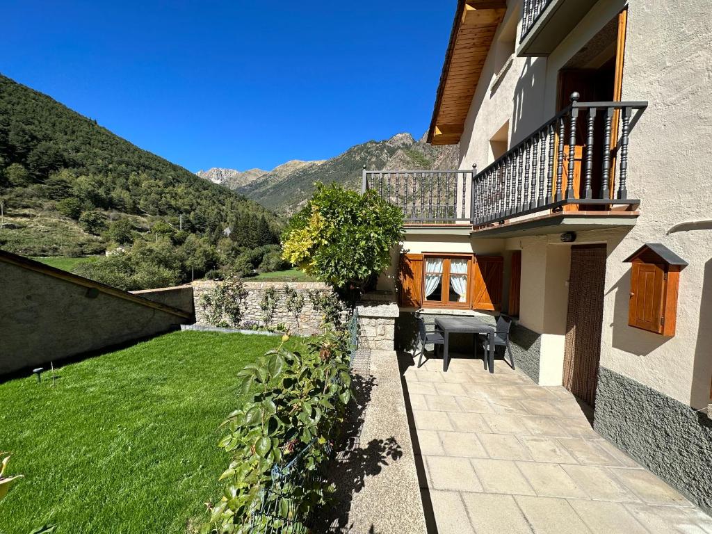 a house with a balcony and a green yard at Apartament Casa Sastre in Espot