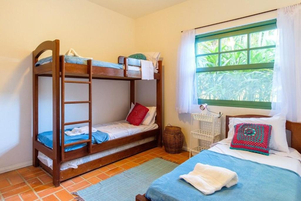 una camera da letto con due letti a castello e una finestra di itamambuca condominio - Cabana Surf a Ubatuba