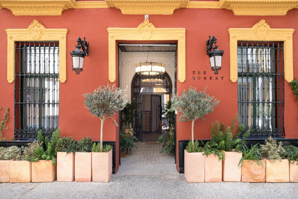 um edifício vermelho com plantas em frente em The Honest Hotel em Sevilha