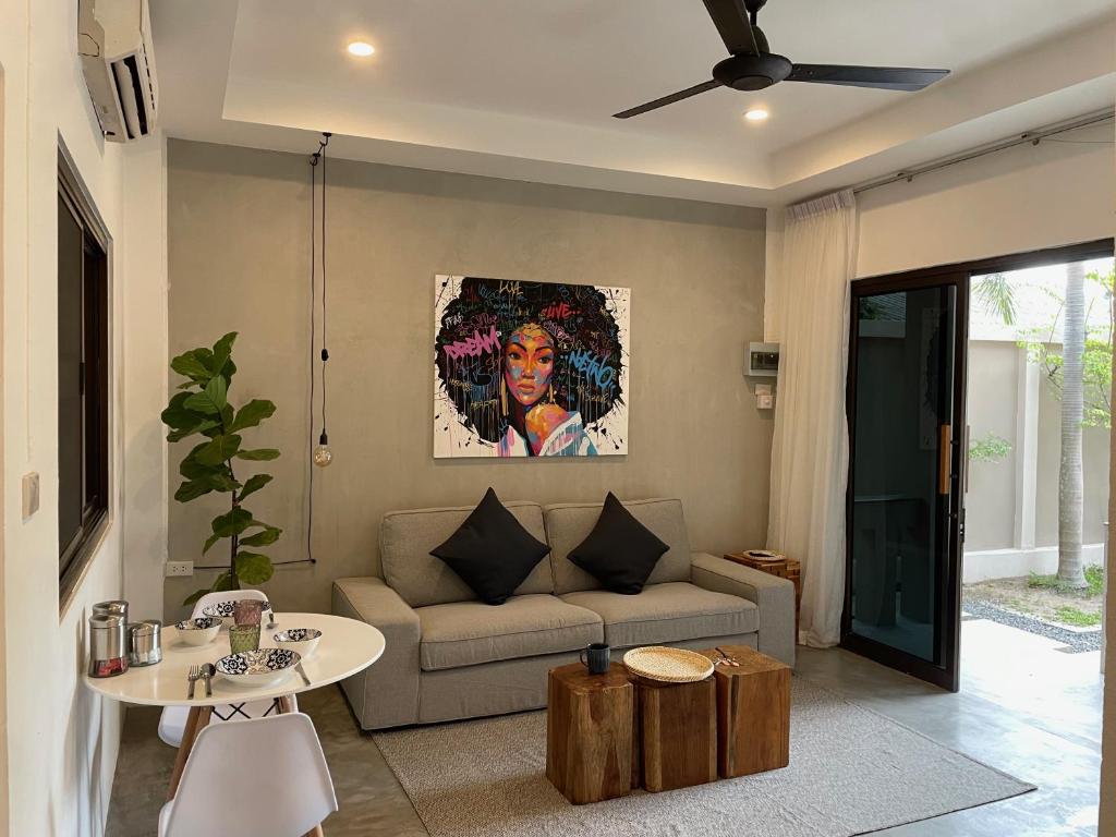 a living room with a couch and a table at PATAMAAN COTTAGES in Amphoe Koksamui