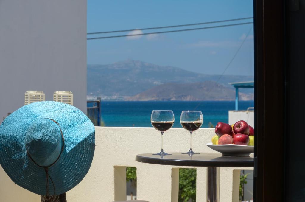 a table with two glasses of wine and a bowl of fruit at Villa Christine in Agia Anna Naxos