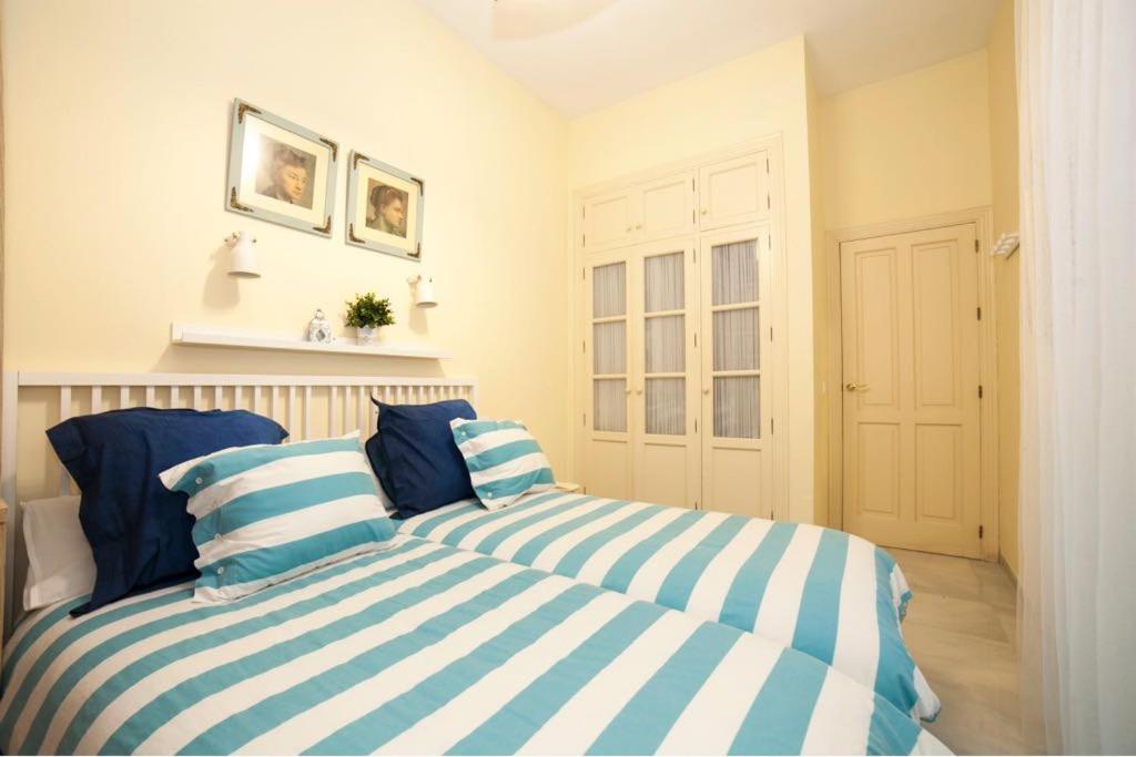 1 dormitorio con 2 camas y almohadas azules y blancas en Magic Point Las Setas, en Sevilla