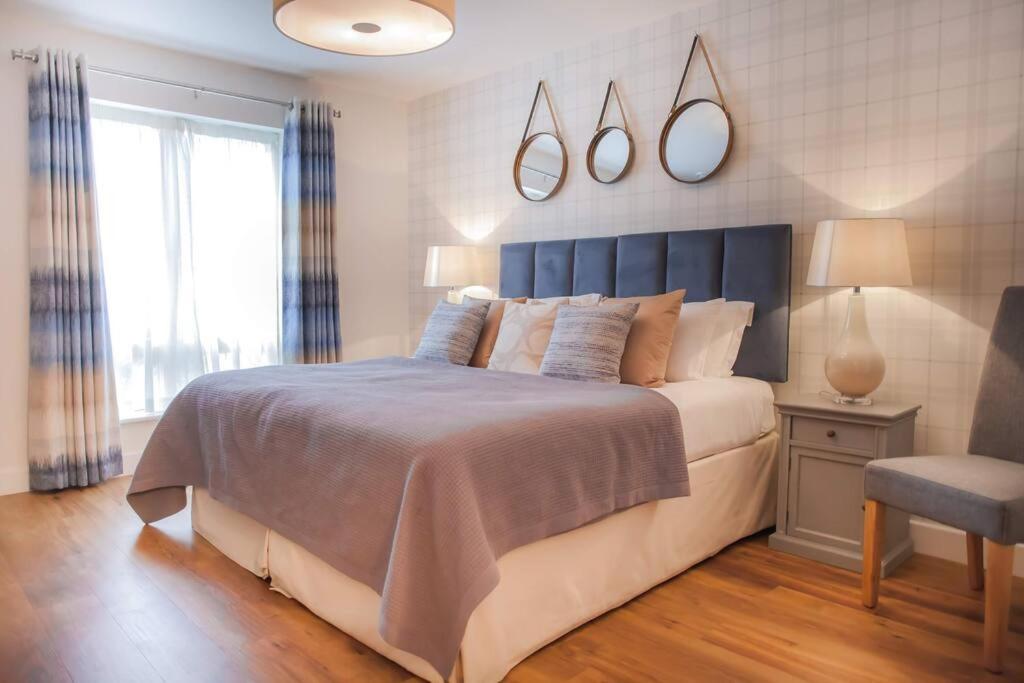 a bedroom with a large bed and a chair at Modern & central - two bedroom & two bathroom apartment in Bath
