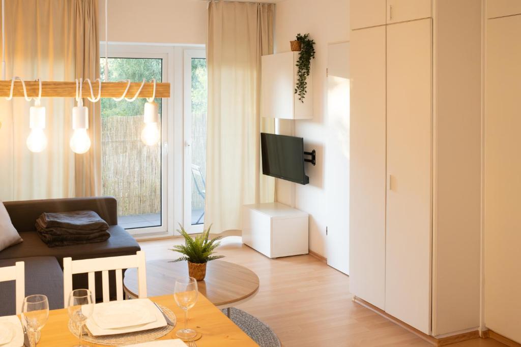 ein kleines Wohnzimmer mit einem Tisch und einem TV in der Unterkunft Ruhige Ferienwohnung 100 m zum Schönberger Strand mit Terrasse in Schönberger Strand
