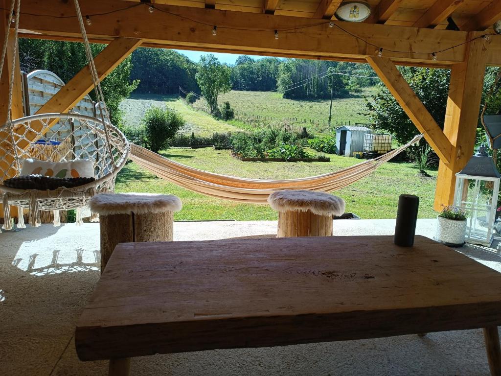 une table en bois avec un hamac et une balançoire dans l'établissement Elise cornu, à Mantry